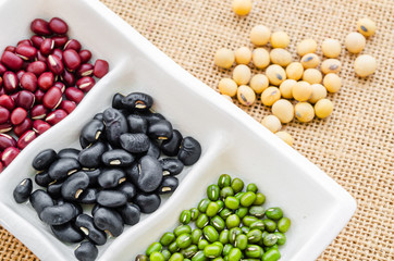 Multicolored beans in white bowl .