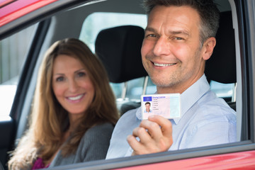 Man Sitting Inside The Car Showing Driving License
