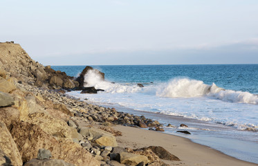 Beach landscape in Malibu. The ocean and waves during strong winds in United States, California. Waves breaking on the rocks.
