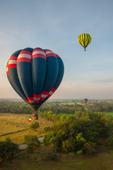 Colorful hot air balloons over green field