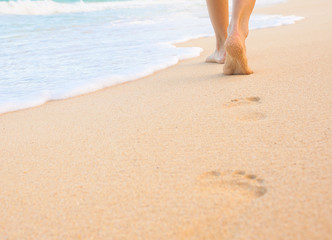Fototapeta na wymiar Foot prints in the sand. Feet walking on the beach. 