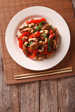 chicken pieces fried with vegetables and cashew nuts closeup. Vertical top view

