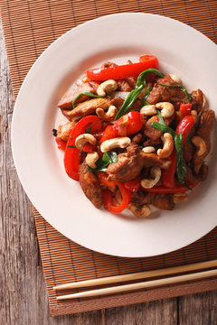 Thai chicken with vegetables and cashew close-up. vertical top view
