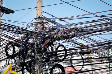 The chaos of cables and wires on every street in Bangkok, Thailand.  