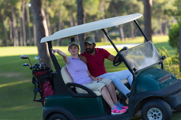 couple in buggy on golf course