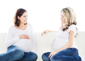 Two attractive expectant mothers chatting with each other