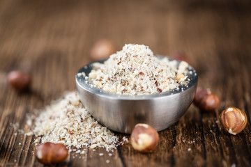 Hazelnuts (grounded) on wooden background