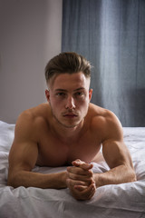 Obraz premium Shirtless sexy male model lying alone on his bed