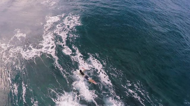 A Surfer "Duck Dives" Underneath a Wave Near Maui, Hawaii in Blue Ocean Water