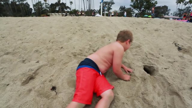 Slow motion of kid smiling at camera and playing at the beach