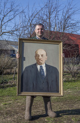 Villager with a portrait of Vladimir Lenin in his hands.