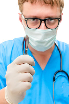 Vertical portrait of a surgeon in the mask with a scalpel