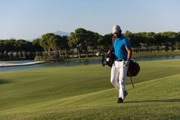 golf player walking and carrying bag