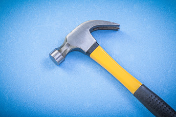 Claw hammer on blue background construction concept