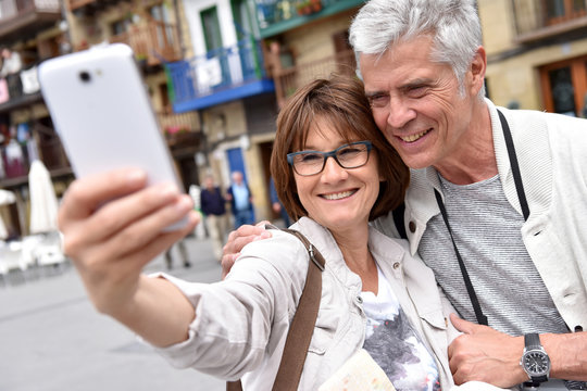 Senior couple taking selfie picture with smartphone