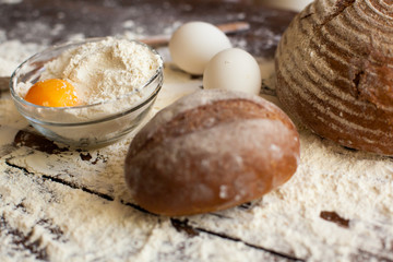 Fototapeta na wymiar Bowl of flour with eggs and bread