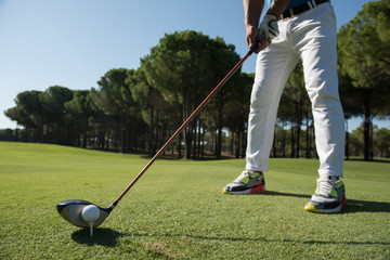 golf player placing ball on tee