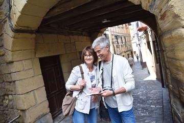 Fototapeta na wymiar Senior couple of tourists visiting spanish little town