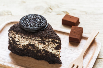 Chocolate cake slice in wooden plate.