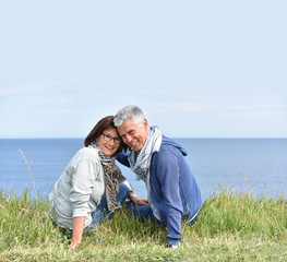 Fototapeta premium Senior couple on rambling day sitting by cliff