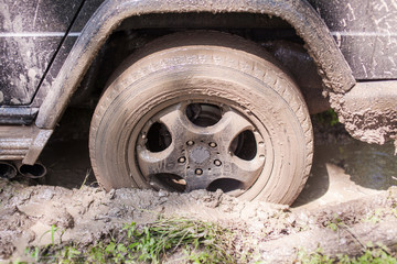 Fototapeta na wymiar SUV got stuck in the mud, wheel closeup