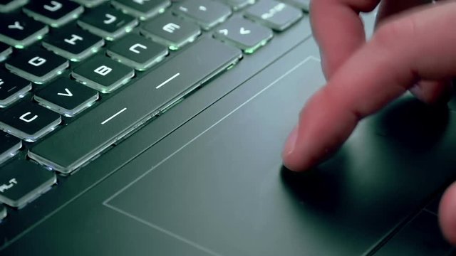 man using touchpad on notebook keyboard with his finger