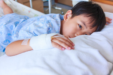 Obraz na płótnie Canvas Asian boy lying on sickbed, saline intravenous (IV) on hand.