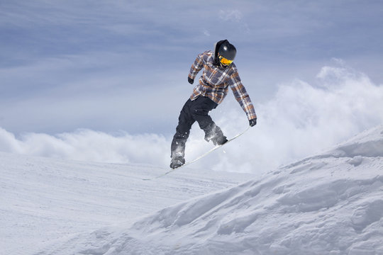 Snowboard rider jumping on mountains. Extreme snowboard freeride sport.