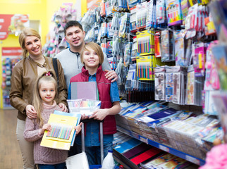 Parents with children buying writing materials