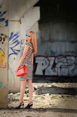 blonde girl standing wearing dress near column inside ruins