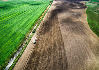 harvester plowing field in spring, view from height