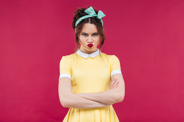 Sad frowning pinup girl standing with arms crossed