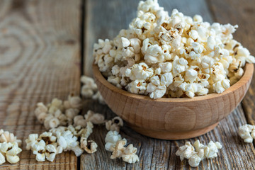 Popcorn in wooden bowl closeup.