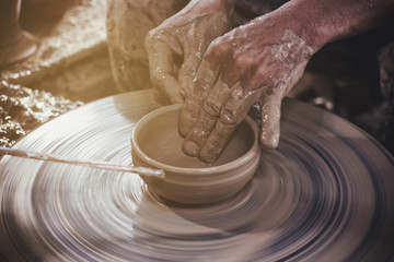 Potter makes on the pottery wheel clay pot.