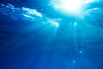 Fototapeta na wymiar Underwater shot with sunrays in deep blue tropical sea