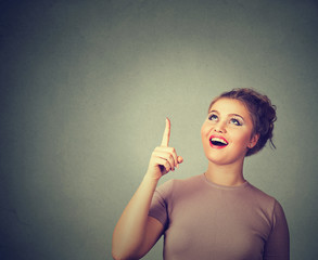 Obraz premium woman thinking looking up pointing with finger at blank copy space