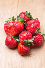 Red fresh strawberry fruits on wooden table.