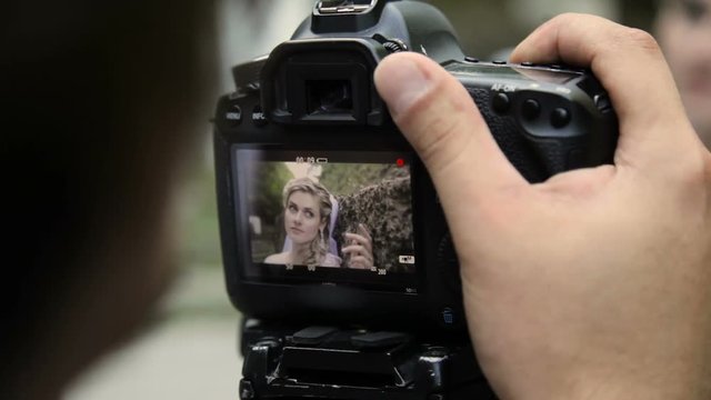 looking on camcorder display during shooting women - Powered by Adobe