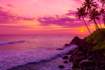 Foto auf Acrylglas Antireflex Warmer bunter tropischer Sonnenuntergang über dem Ozean mit Kokospalmensilhouetten am ruhigen Sommerstrand auf dem Inselresort © nevodka.com