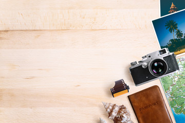 Travel and vacation concept. Vintage rangefinder film camera, old photos, film roll, sea shells, passport and map. Top view with copy space