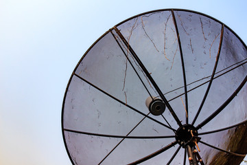 Satellite dish standing on the roof with the blue sky.
