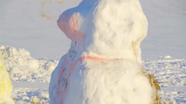 The big boobsy snowman on the ground with a red paint all over her body
