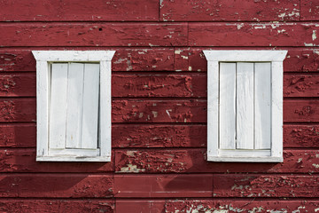 Fototapeta na wymiar Pair of Old White Barn Windows: An old pair of white painted barn windows now boarded up