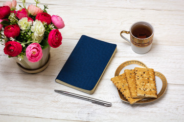 notepad and cup of tea on white boards