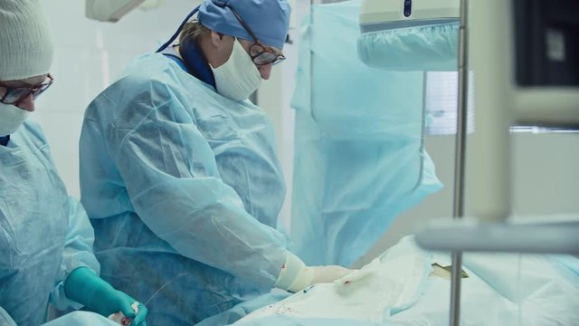 Female doctor performing coronary artery bypass graft assisted by nurse in operating room, shot on Sony NEX 700 + Odyssey 7Q