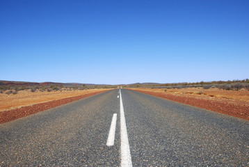 Fototapeta na wymiar Long straight road through outback wasteland, Northern Territory, Australia