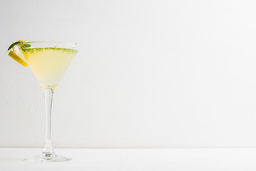Yellow martini cocktail with lemon and mint on the rustic wooden background