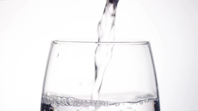4K Water filling up the top of a glass, in slow motion