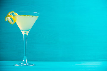 Yellow martini cocktail with lemon and mint on the rustic wooden background