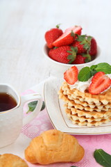 Waffles, mint and ripe strawberries.